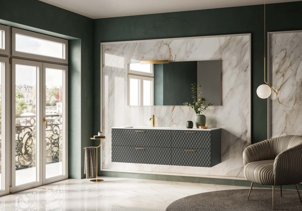 Bagno con parete in marmo, mobile lavabo scuro, dettagli dorati, grande specchio e porte finestre.