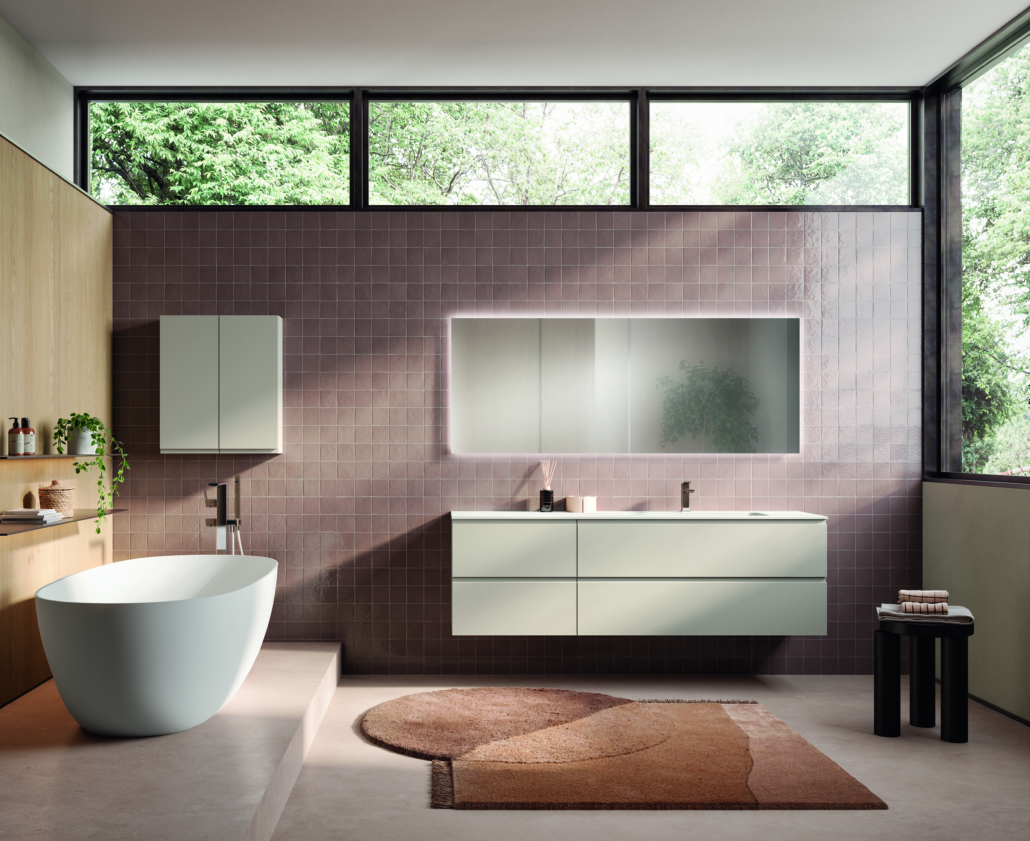 Bagno moderno con vasca, mobile lavabo e finestra con vista sugli alberi. Colori pastello.