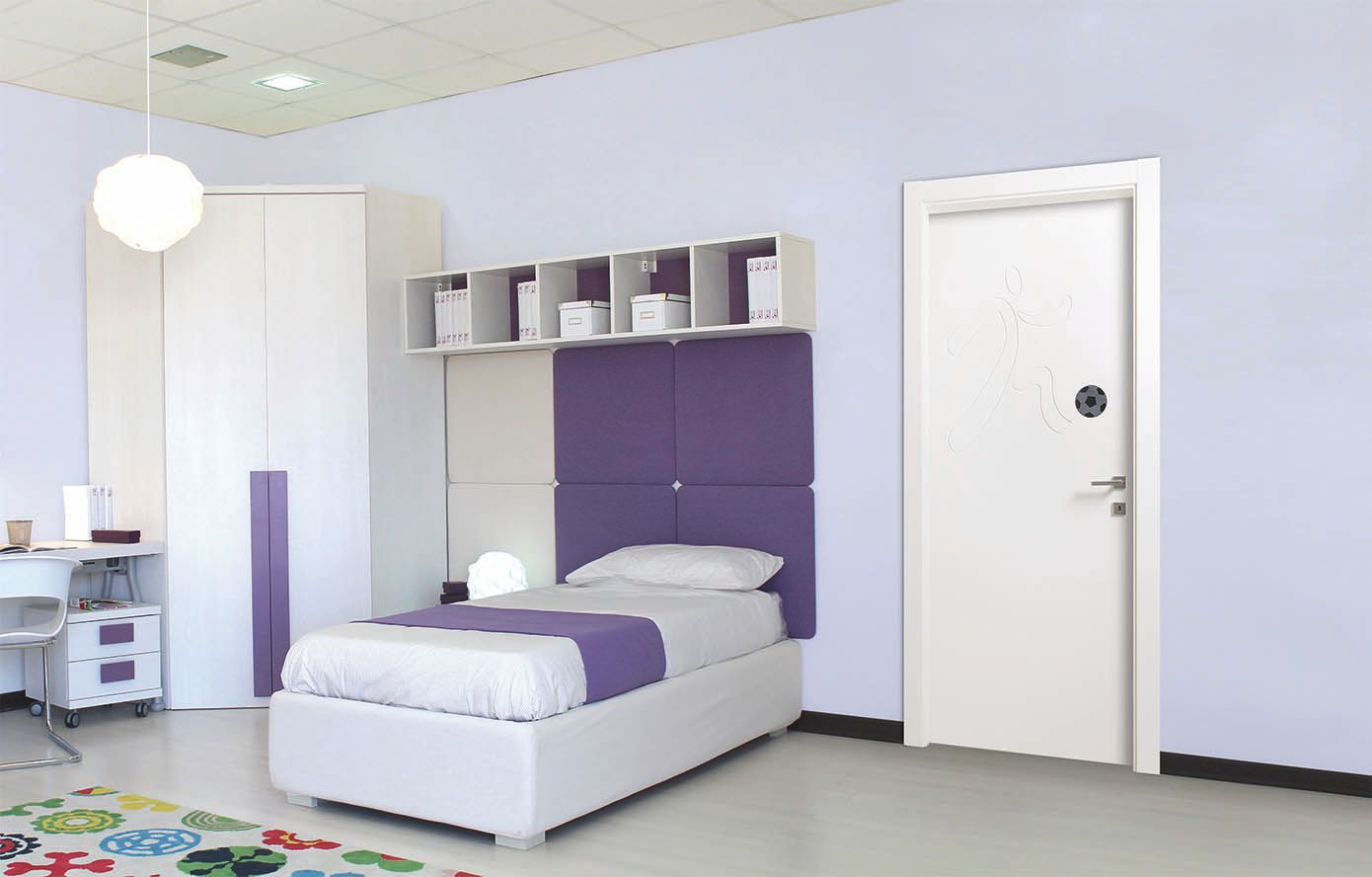 Camera da letto con mobili bianchi, dettagli viola, letto, armadio, scrivania e una porta.