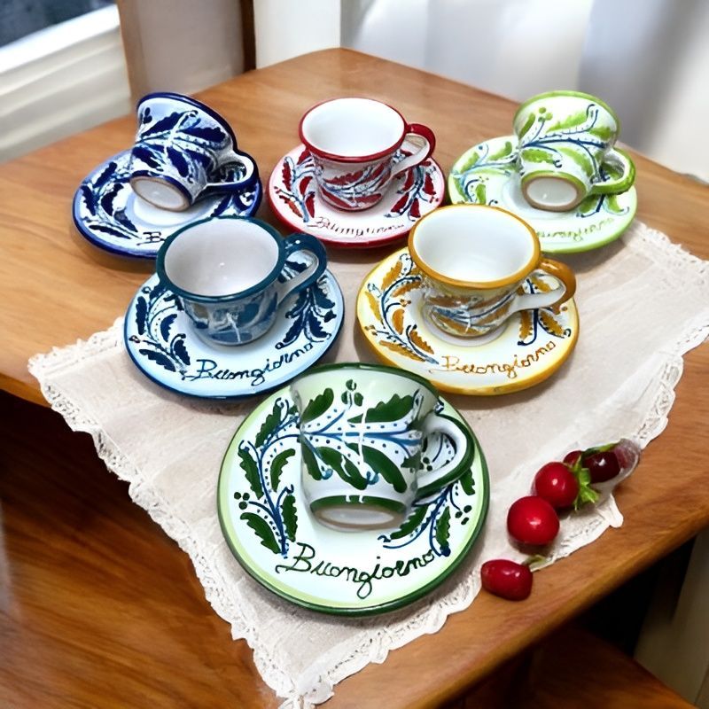 Sei tazze da caffè in ceramica colorata con piattino, ciascuna con un diverso motivo a foglie e la scritta