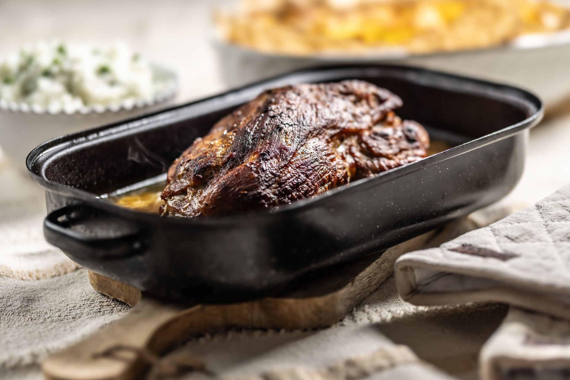 A pan filled with meat is sitting on a table.