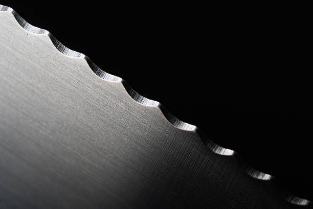 A close up of a circular saw blade on a black background.