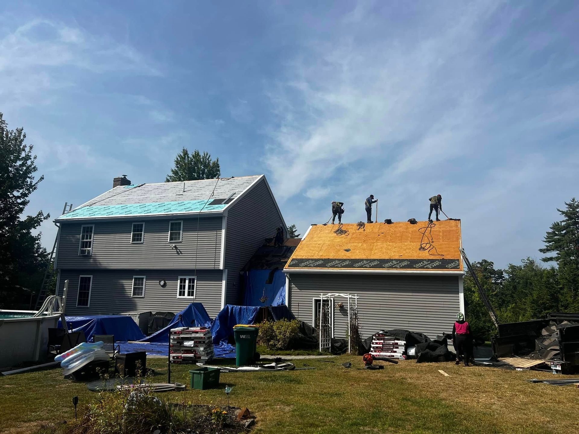 A house and a garage are being remodeled with a roof being installed.