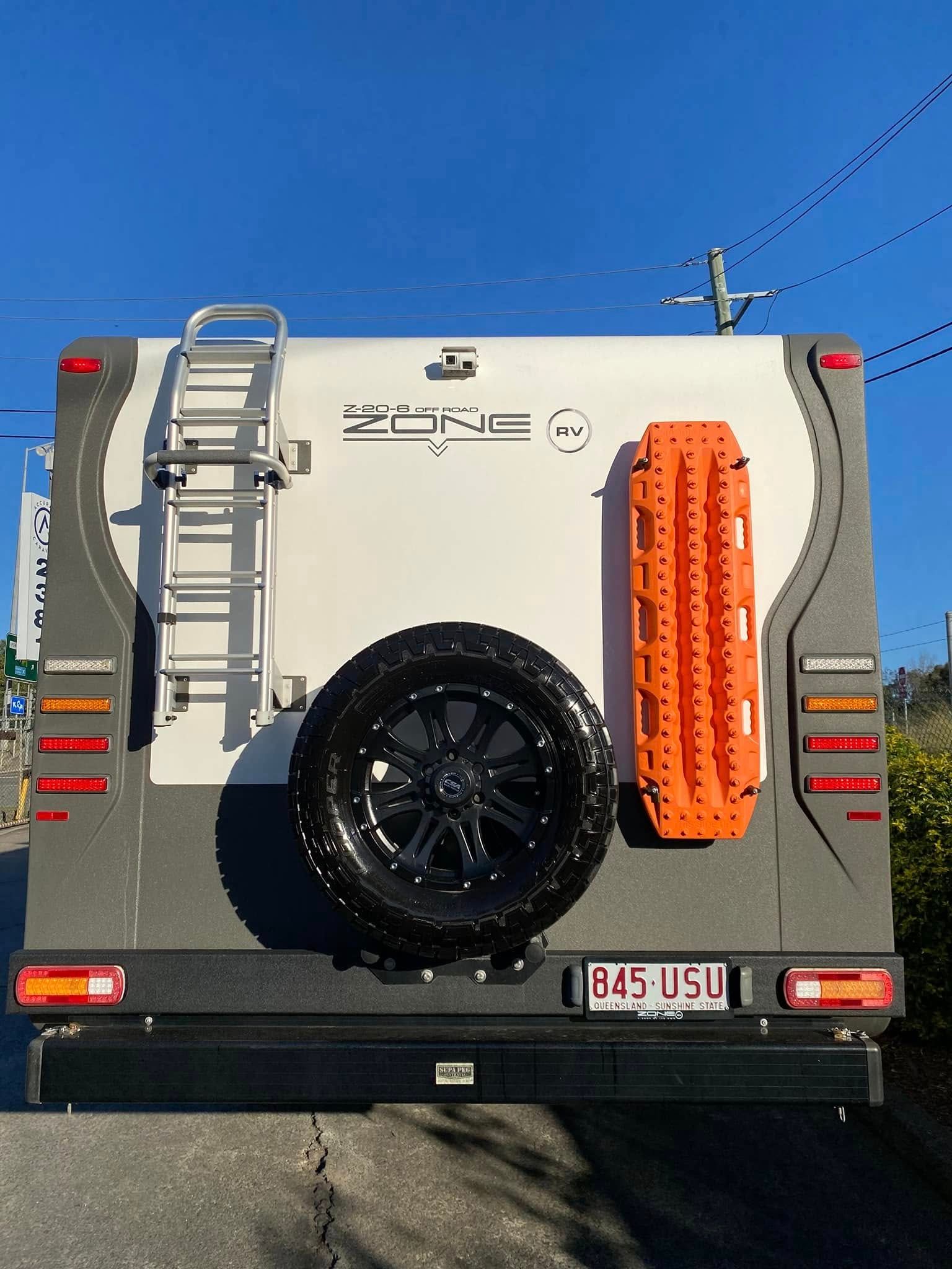Rear View Of A White And Grey Off-road Caravan With Spare Tire, Ladder — Torque Metro Caravan Services in Archerfield, QLD