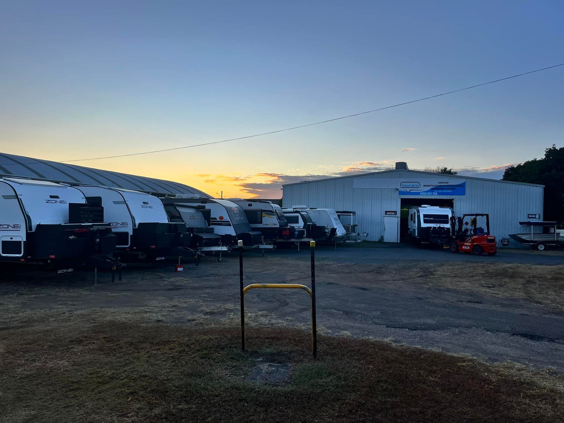Rv Dealership With Rvs Parked Outside A Building At Dusk — Torque Metro Caravan Services in Archerfield, QLD