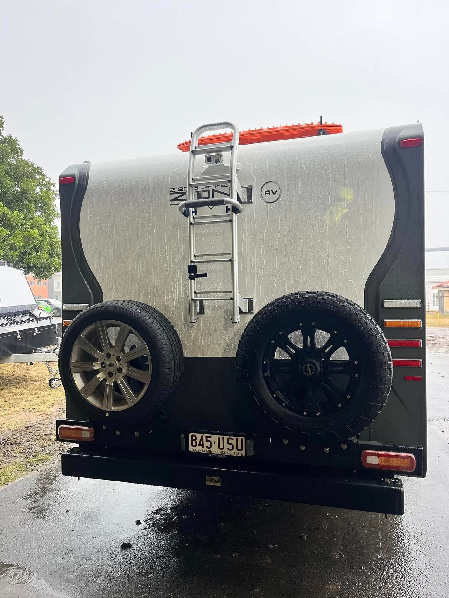 Rear View Of A Silver And Black Camper Trailer With Two Spare Tires — Torque Metro Caravan Services in Archerfield, QLD