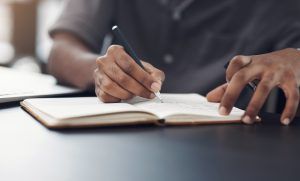 Person Writing in a Notebook