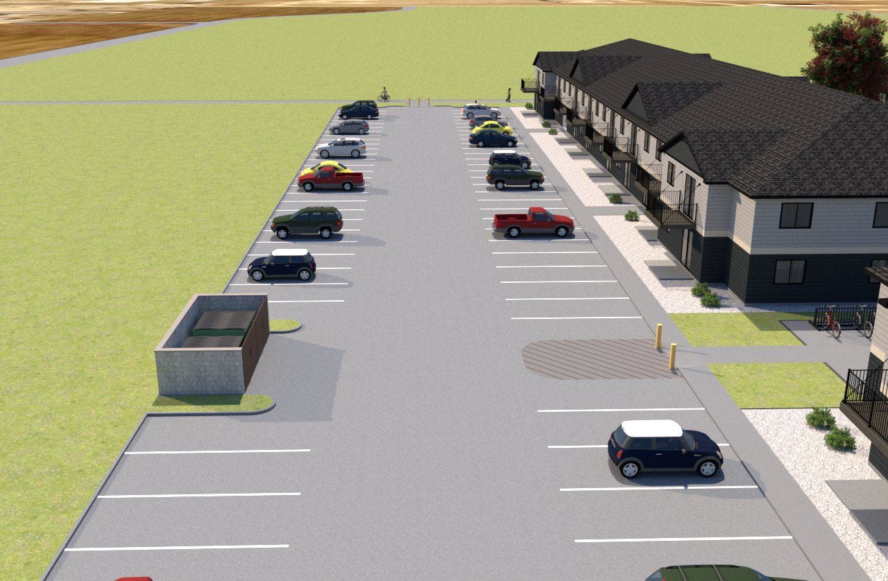 An aerial view of a parking lot with cars parked in front of a building.