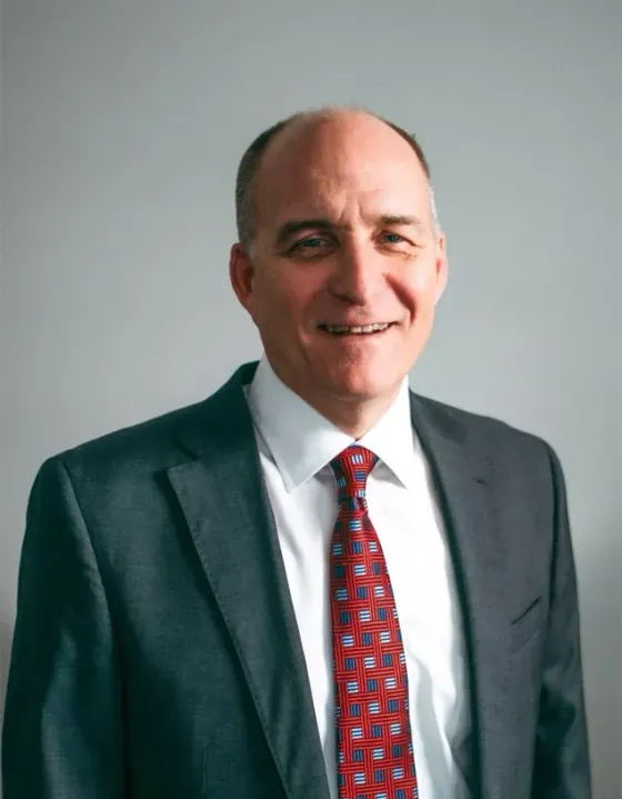 A man in a suit and tie is smiling for the camera.