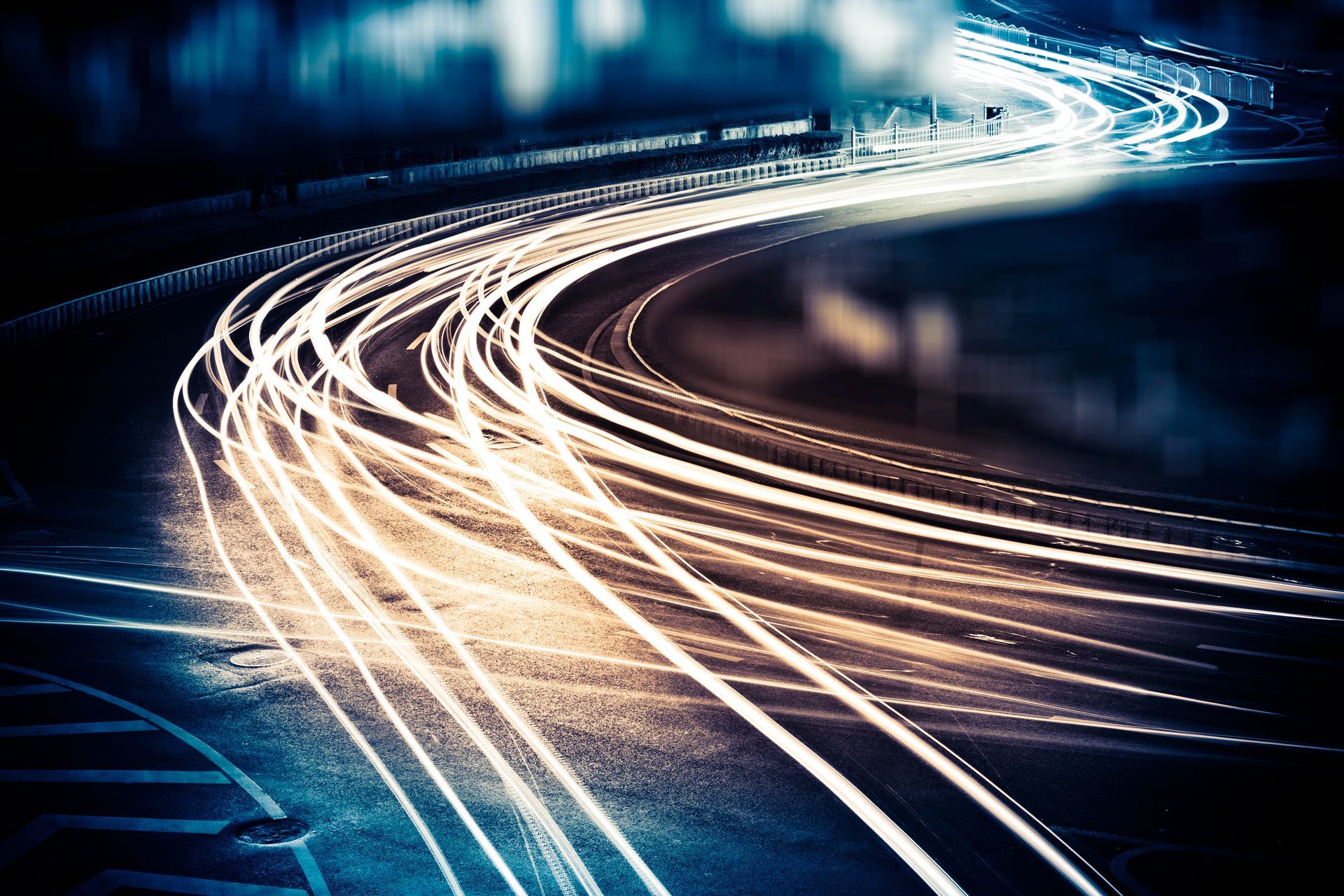 A car is driving down a curvy road at night.