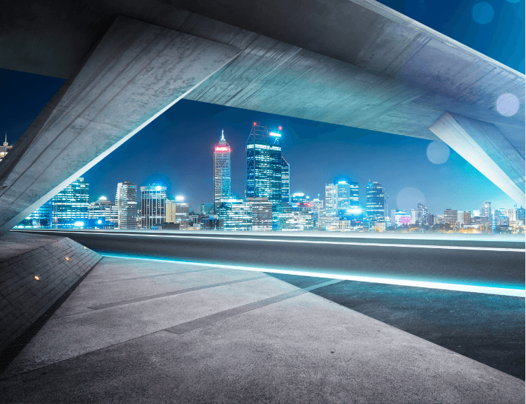 A view of a city at night from under a bridge