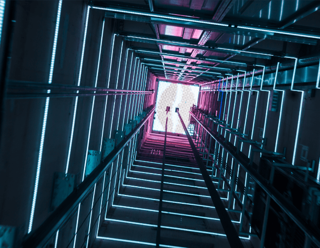The elevator is lit up with neon lights and looks like a tunnel.