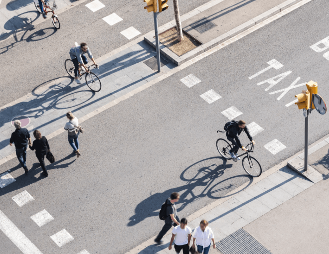 An aerial view of people walking and riding bikes in a taxi lane