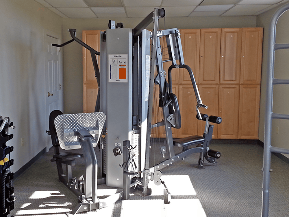 Gym with weight machine and cabinets.