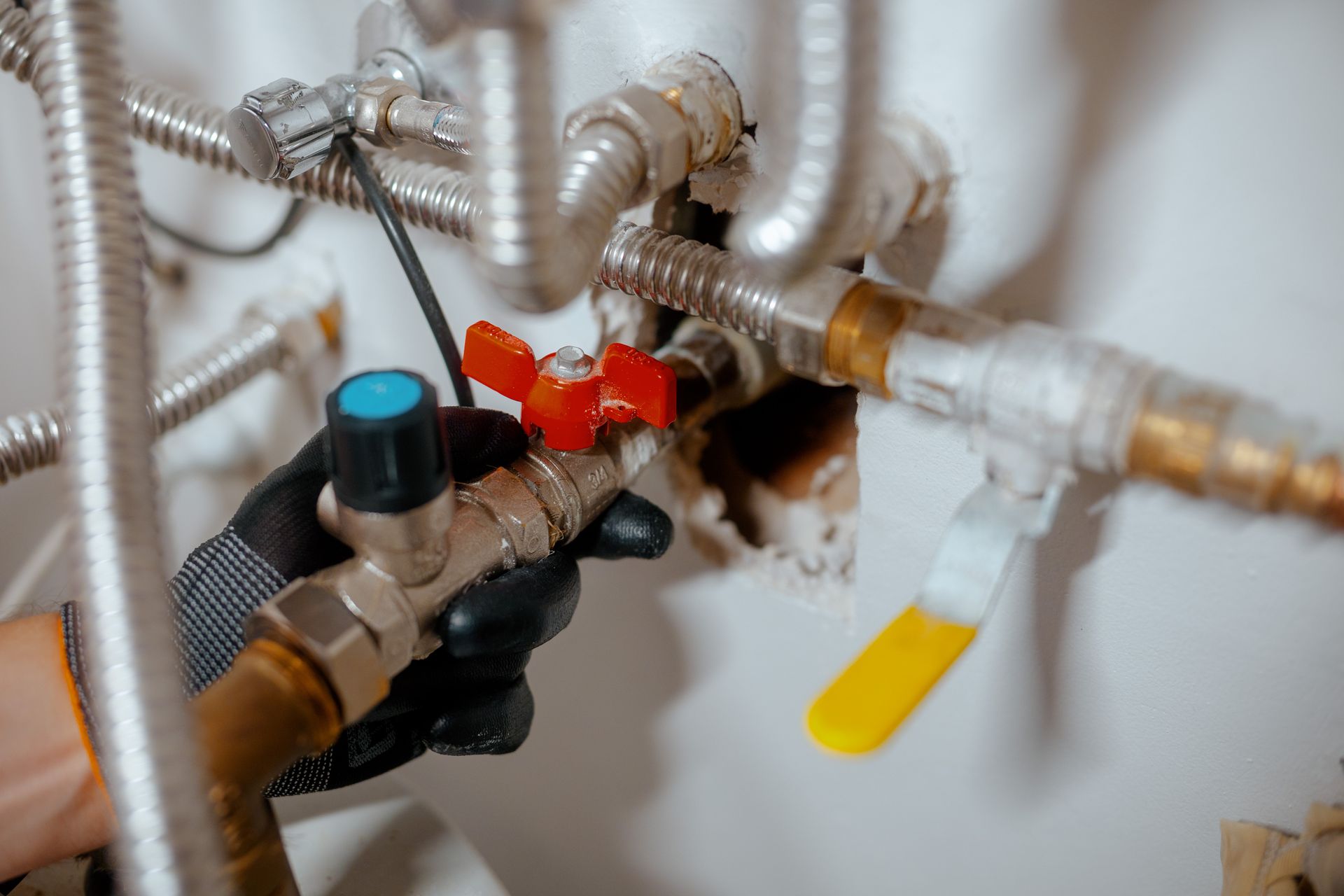 Close-up of a plumbing valve assembly with red and blue handles and silver pipes