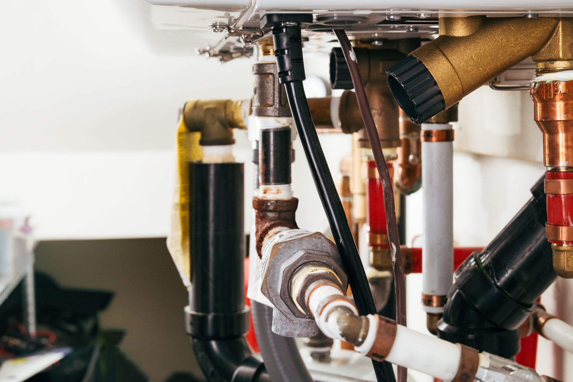 Under-sink plumbing pipes and valves with copper and black tubing