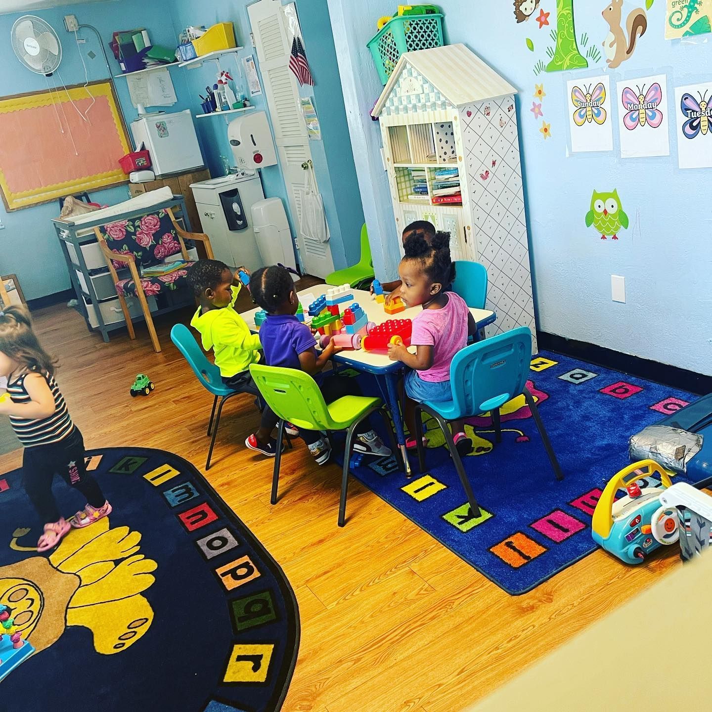 A group of children are sitting at a table in a classroom.