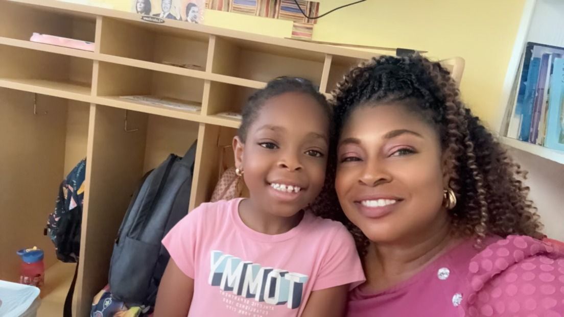 A woman and a little girl are posing for a picture in a locker room.