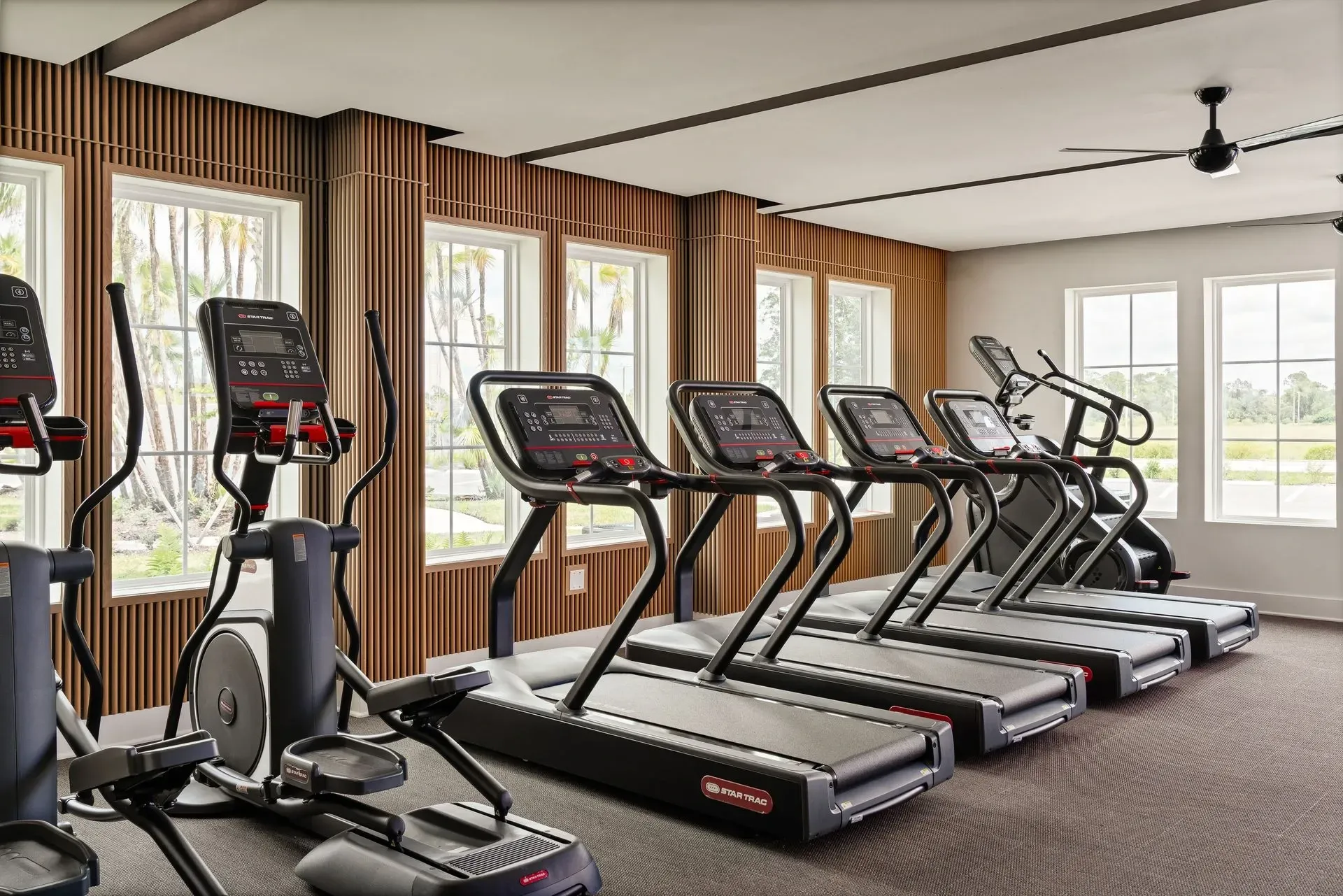 Modern fitness center with treadmills and elliptical machines.