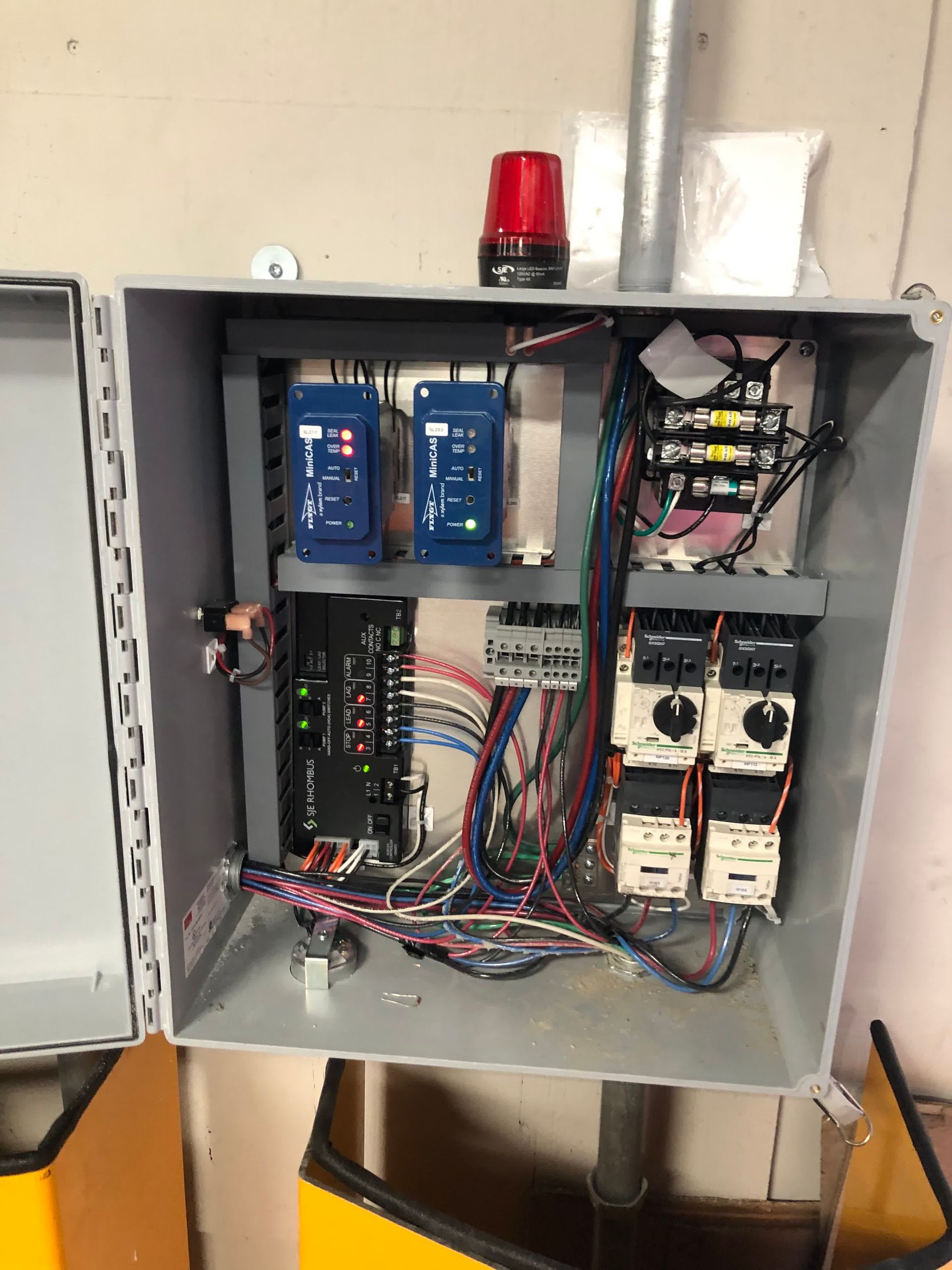 The inside of a electrical box with a red light on top of it.