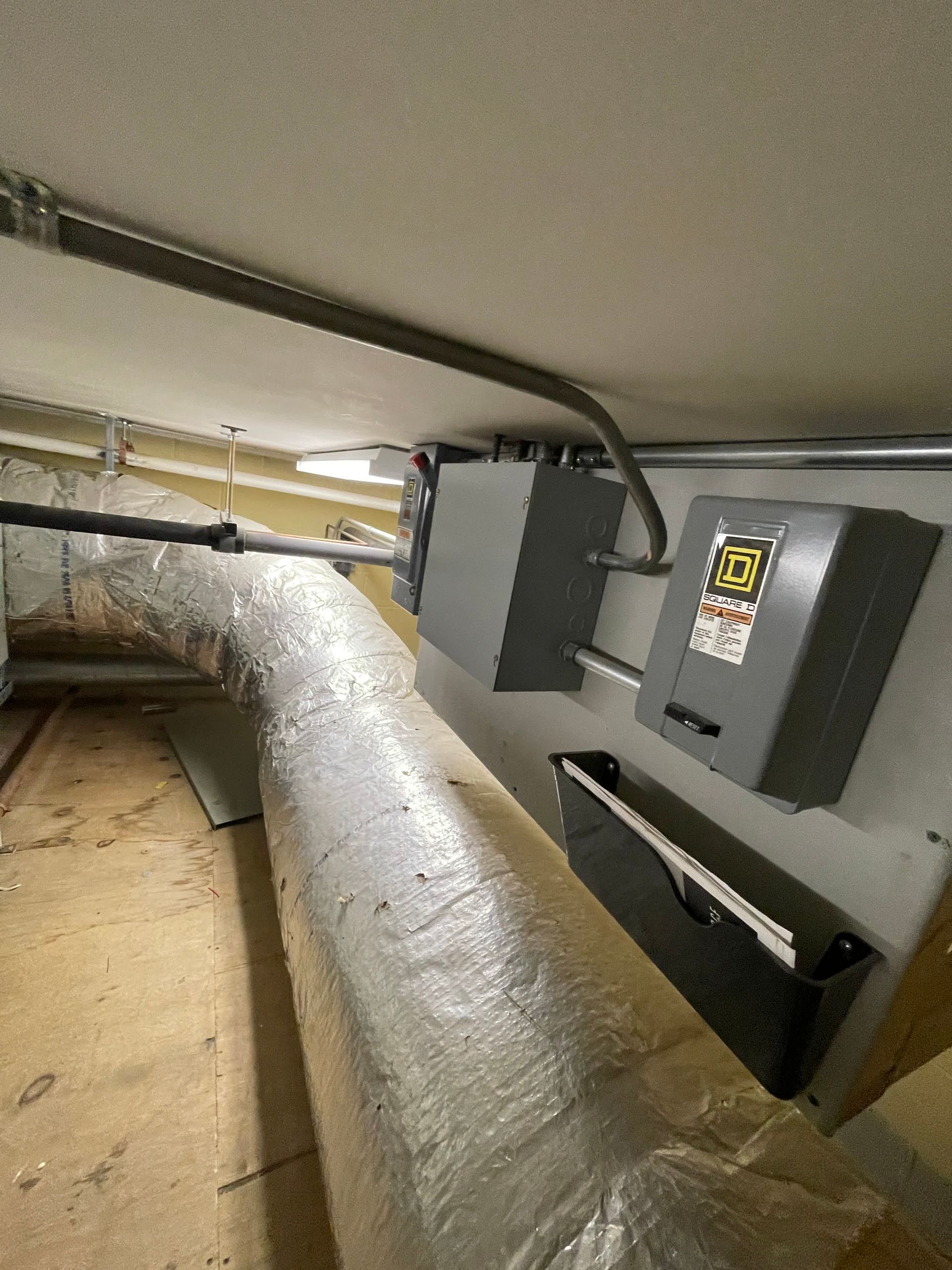 There are a lot of wires hanging from the ceiling in this room.