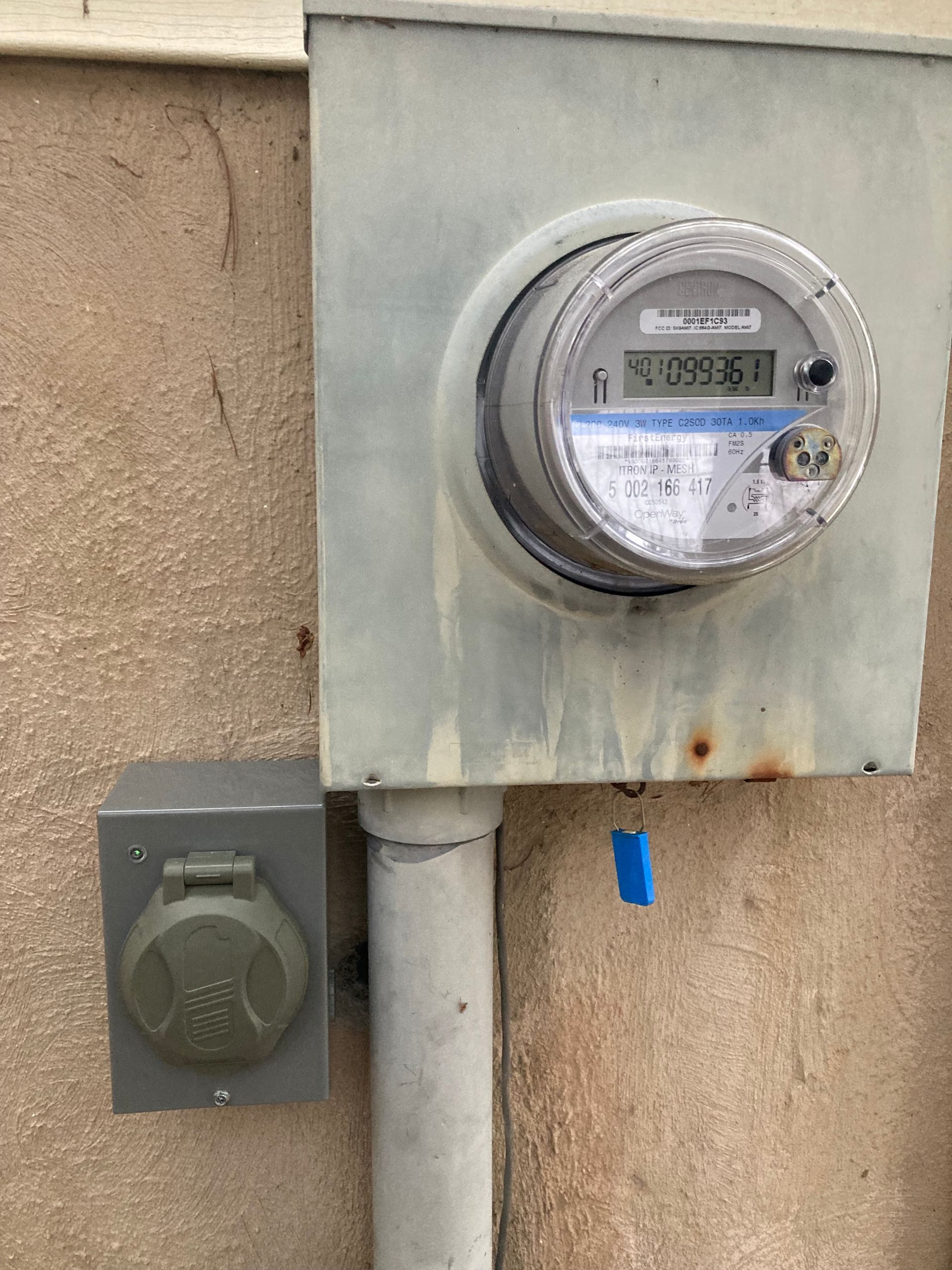 A close up of an electric meter on a wall.