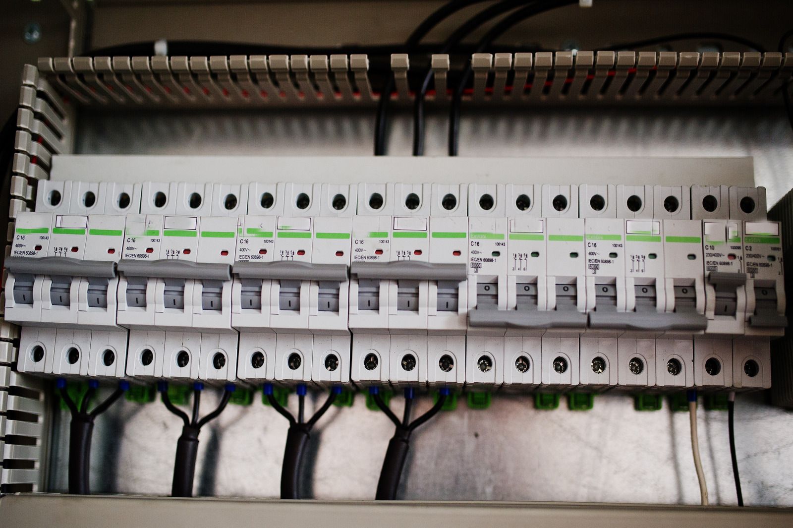 A row of circuit breakers are lined up in a box.
