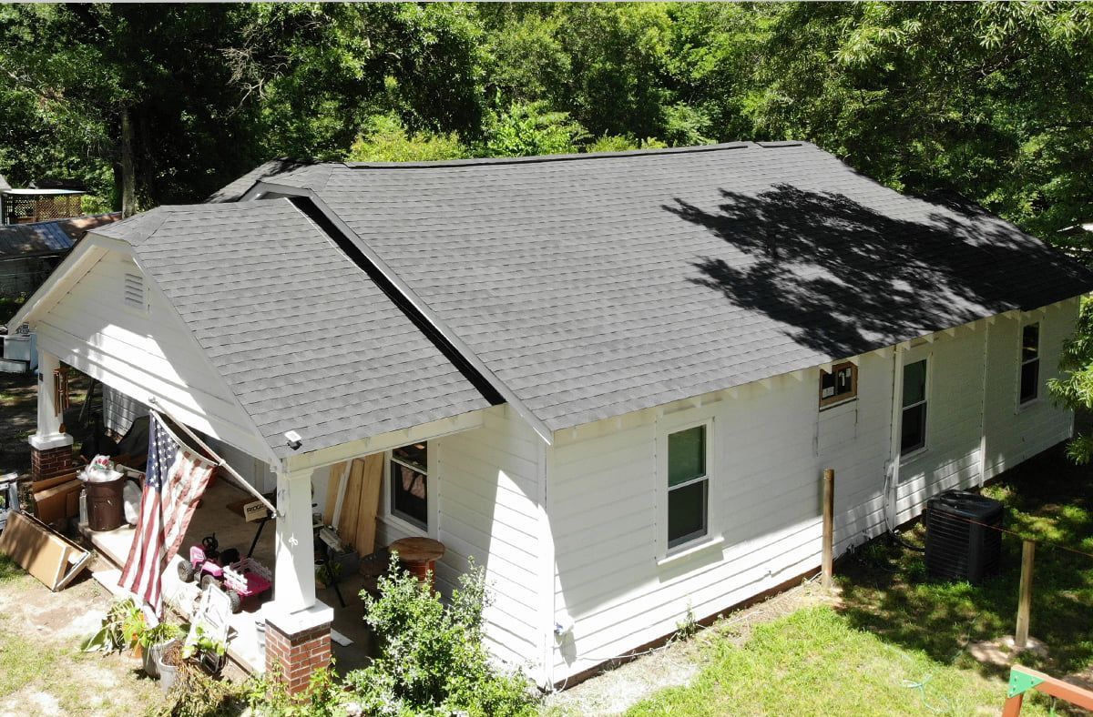 An advertisement for hernandez roofing shows a white house with a black roof