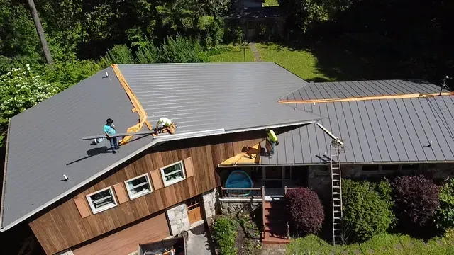 A couple of men are working on the roof of a house.