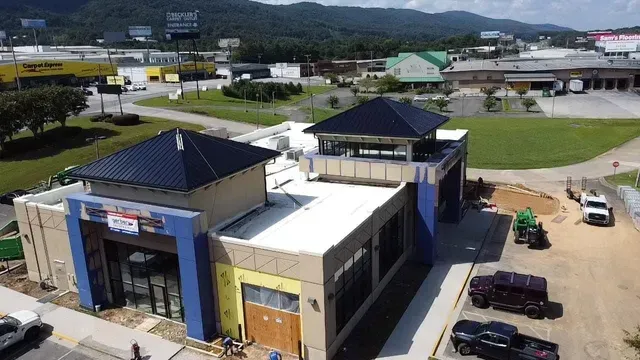 An aerial view of a building under construction with mountains in the background.