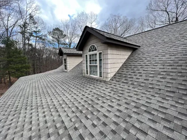 An aerial view of a large house with a gray roof.