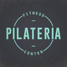 Logotipo do Pilateria Fitness Center em fundo escuro, texto verde-azulado dentro de um círculo.