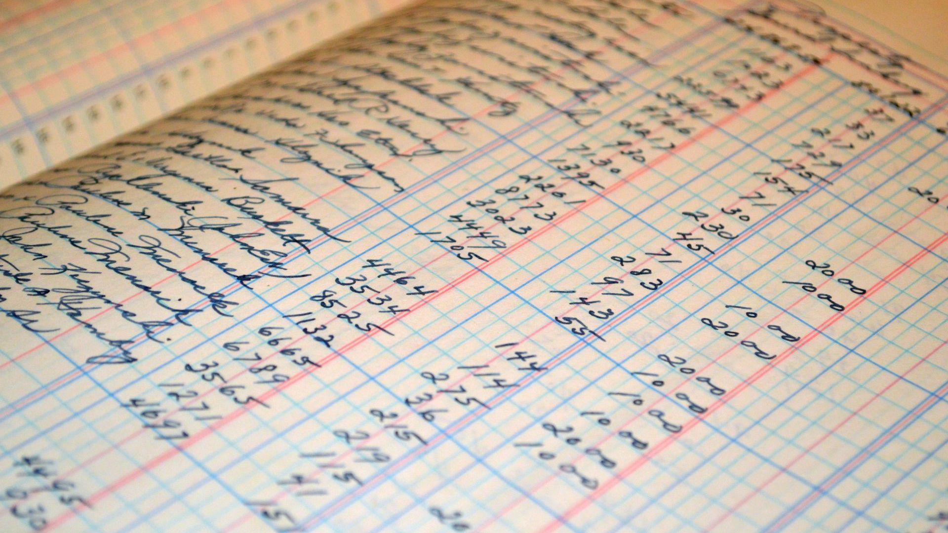 Open ledger book with handwritten financial entries in blue ink.