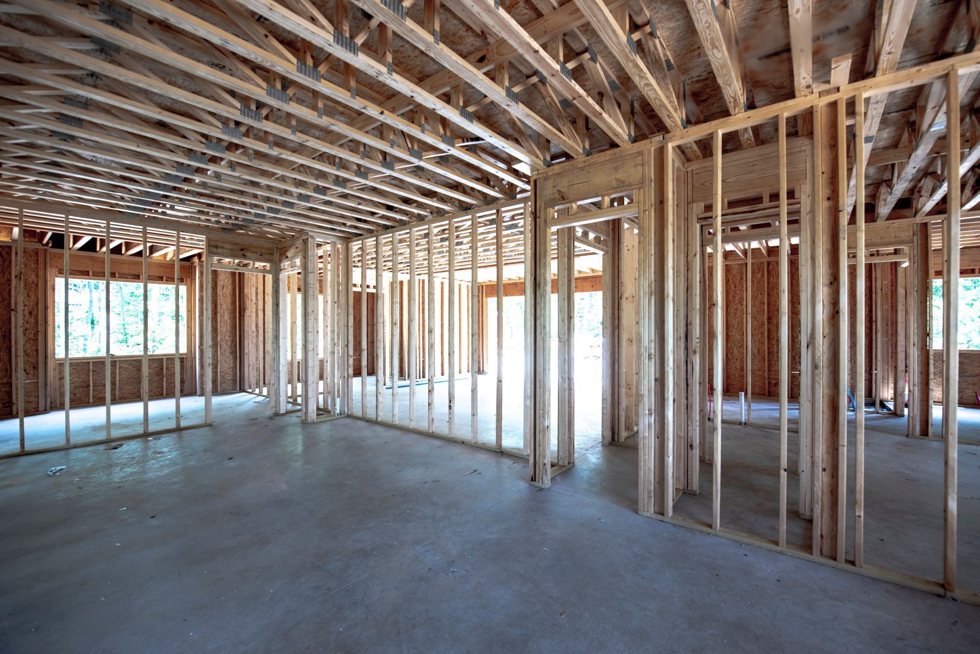 An empty room in a house under construction with wooden beams.