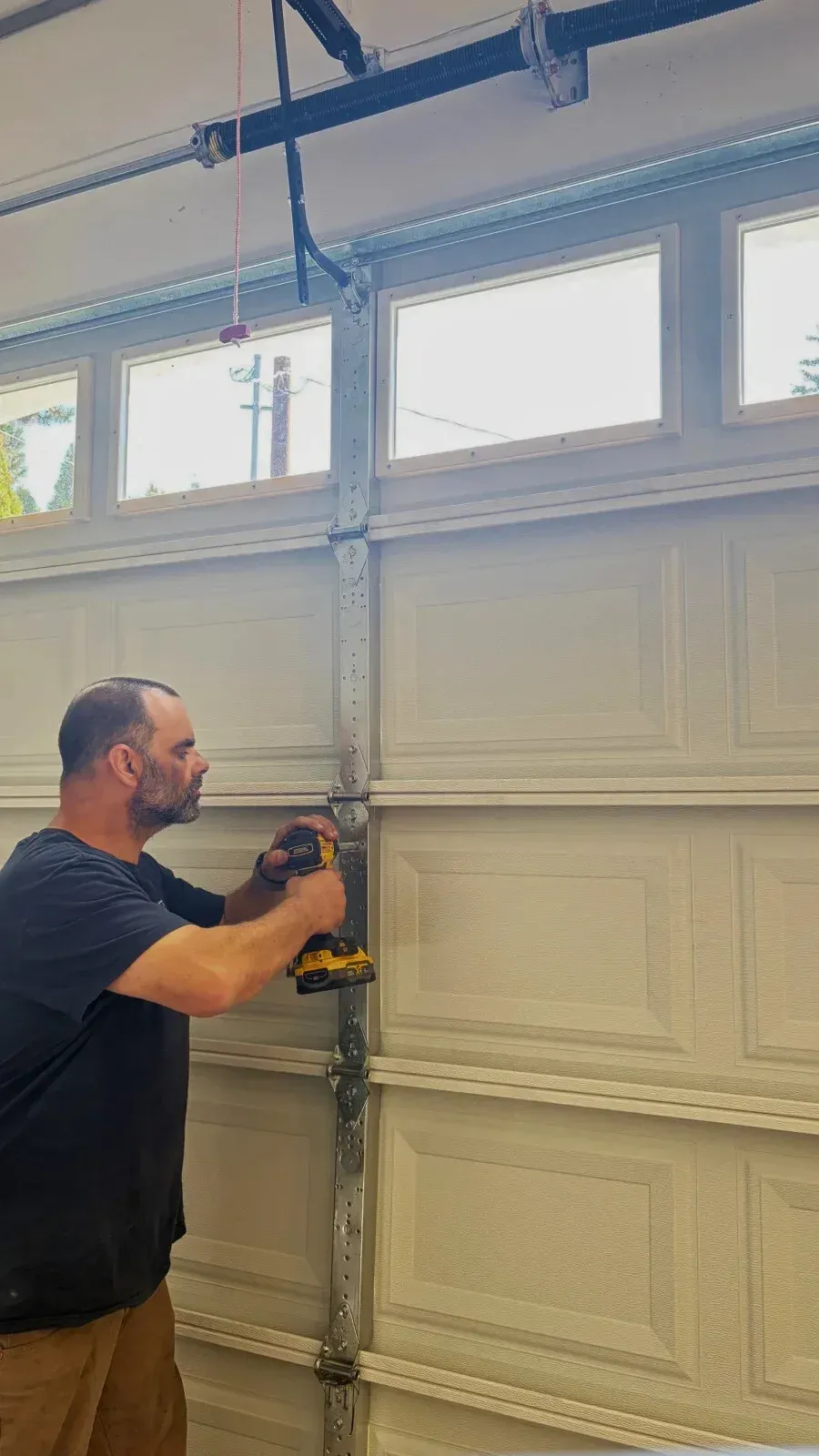 Garage door repair technician working on a residential garage door on the Eastside