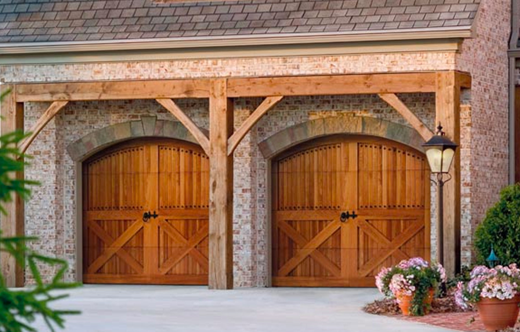 A brick building with two wooden garage doors