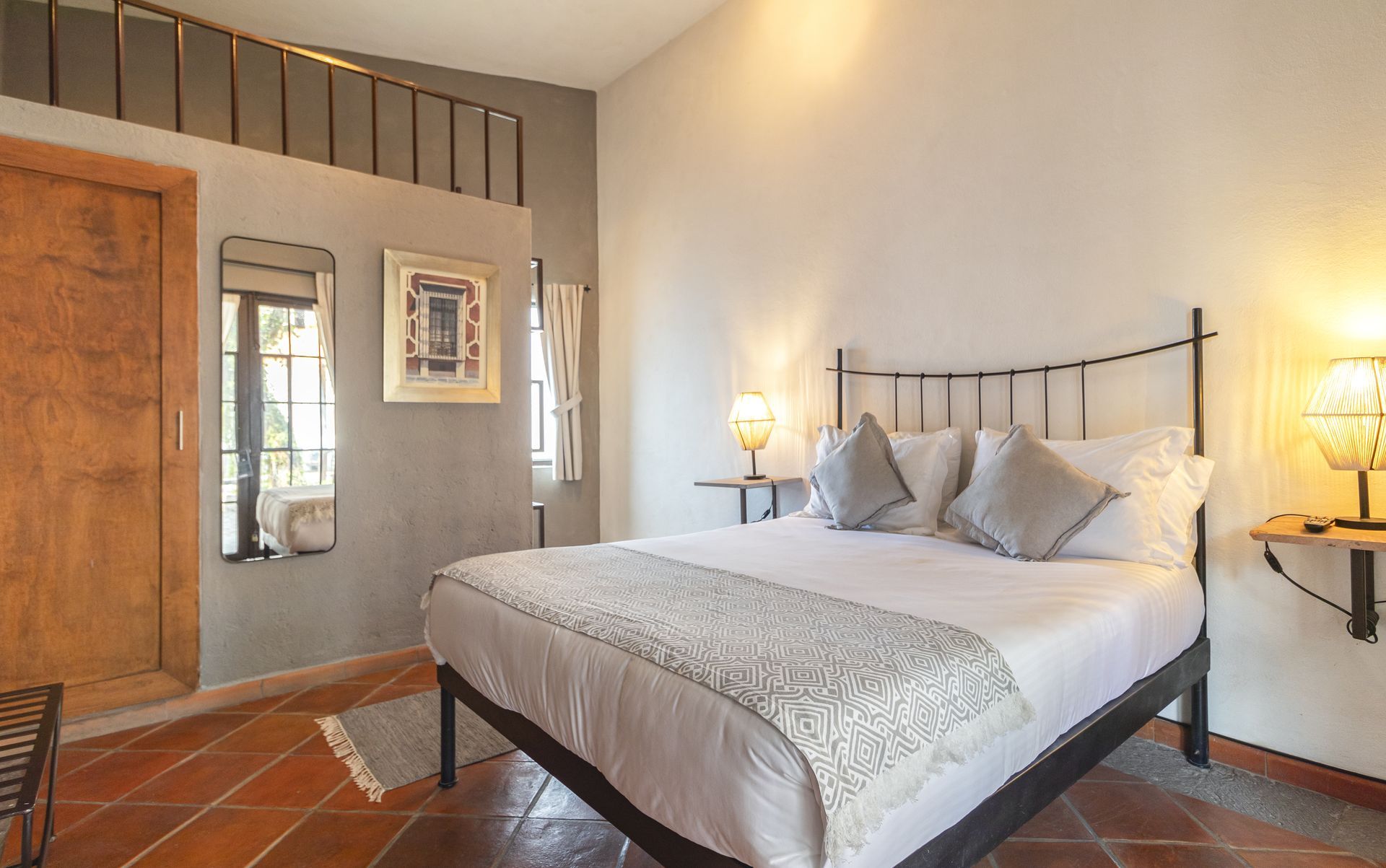 A bedroom with a king size bed and two lamps.