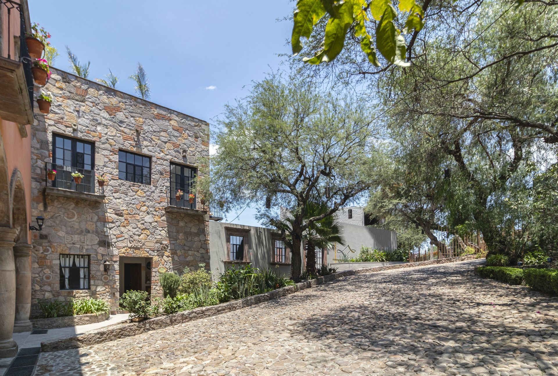 Un edificio de piedra con un camino de entrada adoquinado en frente de él.