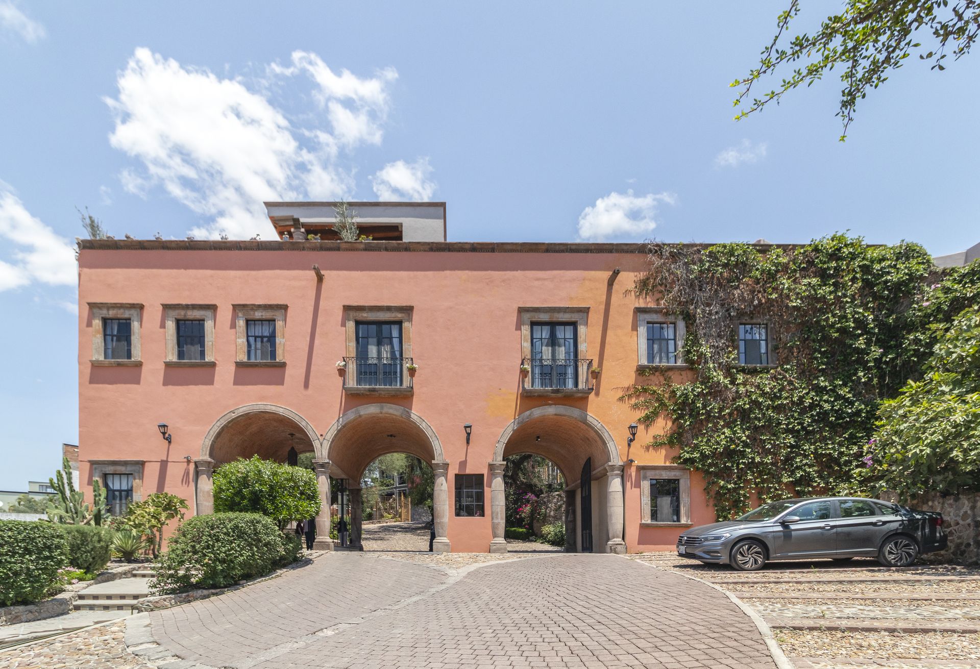 Un gran edificio naranja con coches aparcados delante.