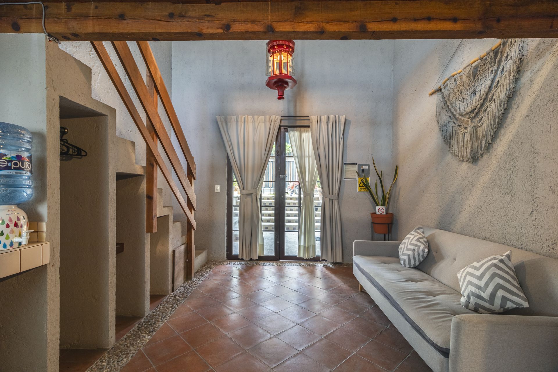 A living room with a couch and stairs leading up to the second floor.