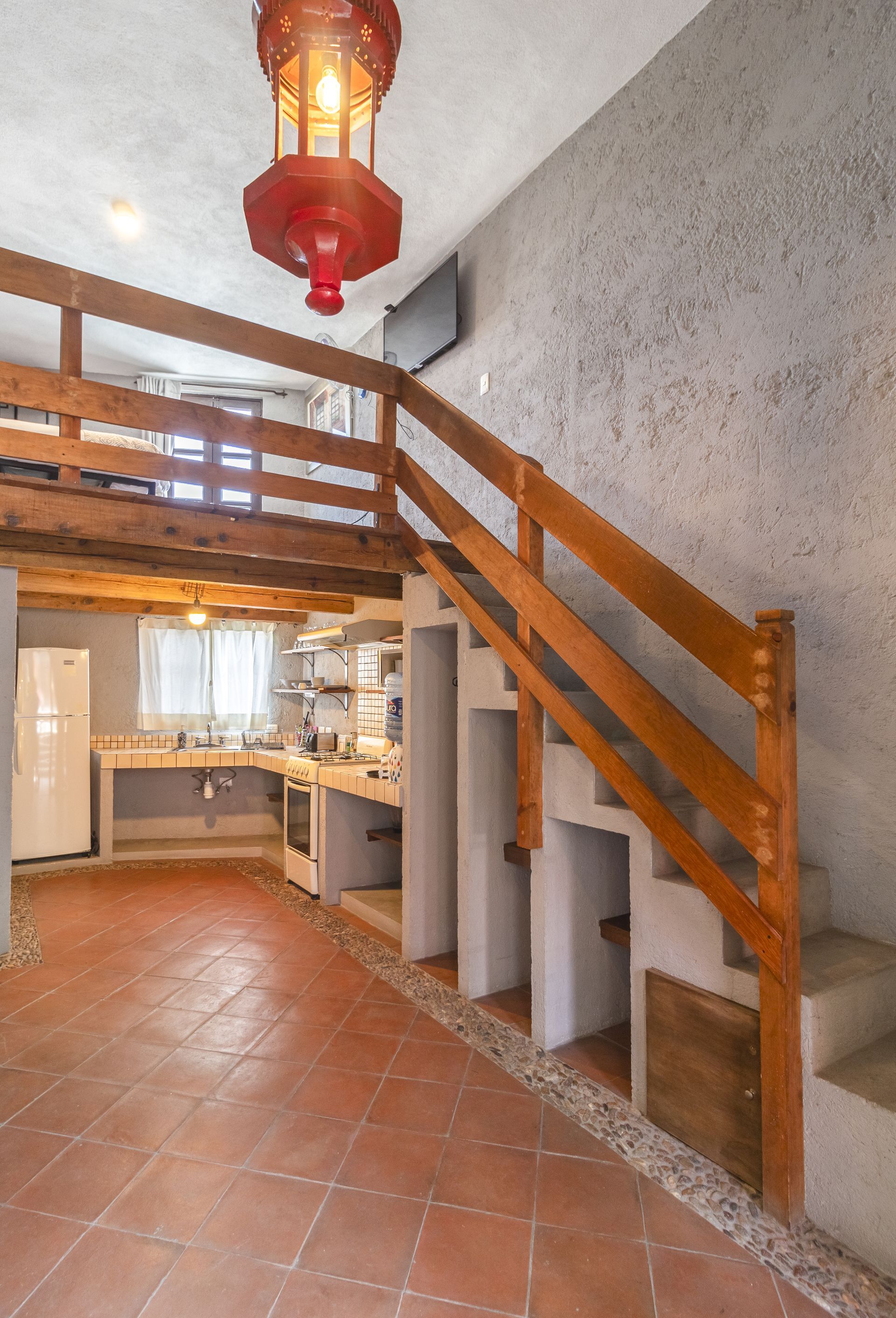 A kitchen with stairs leading up to the second floor
