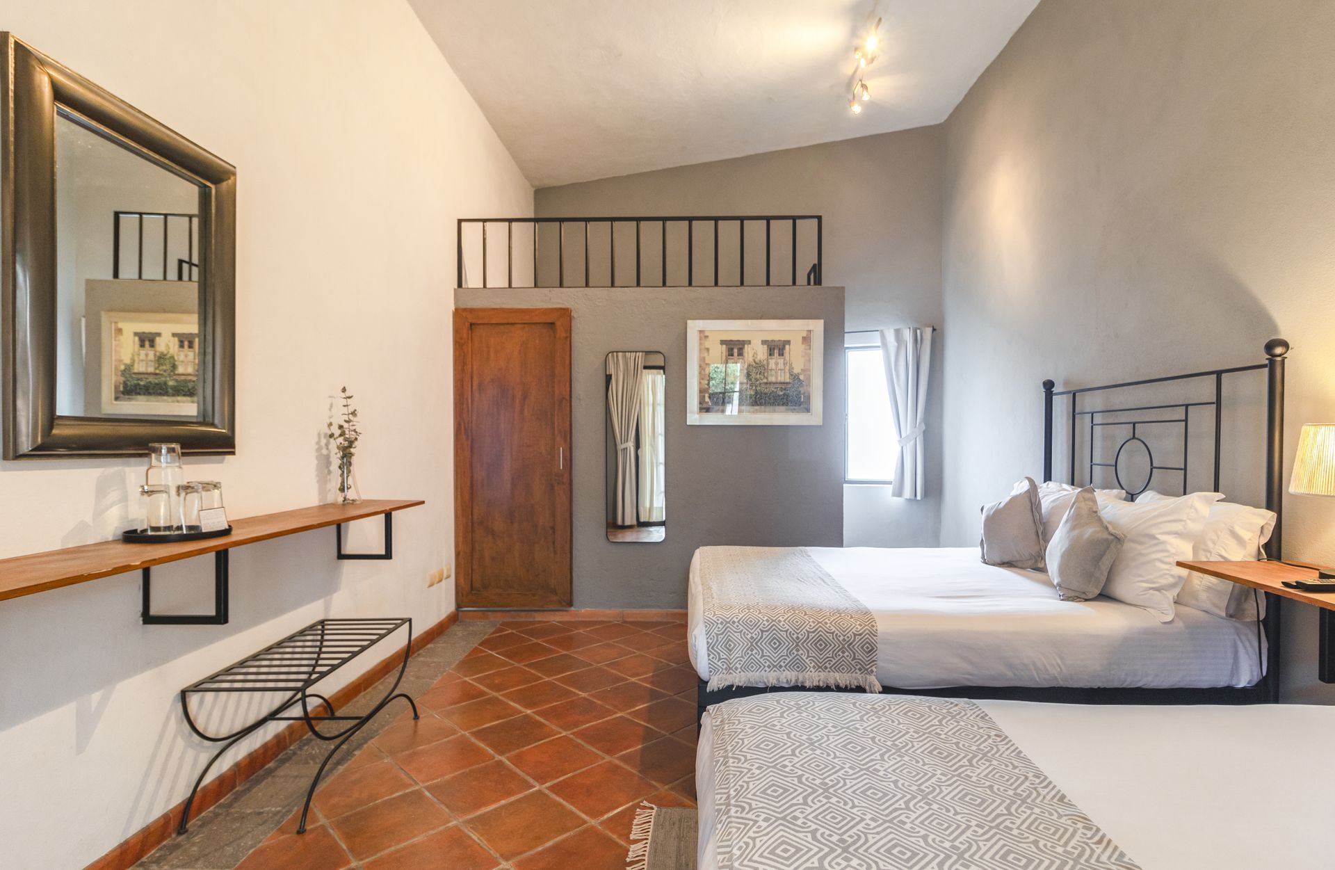 A hotel room with two beds and a mirror.