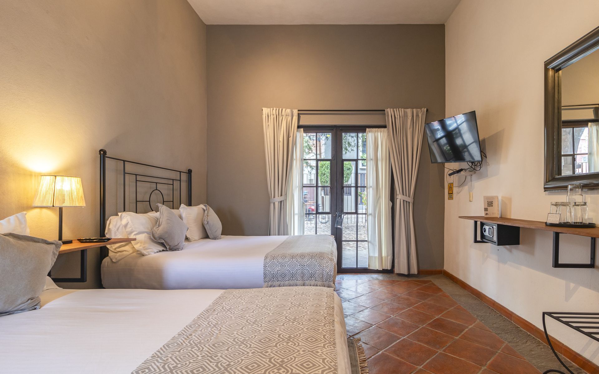 A hotel room with two beds and a television.