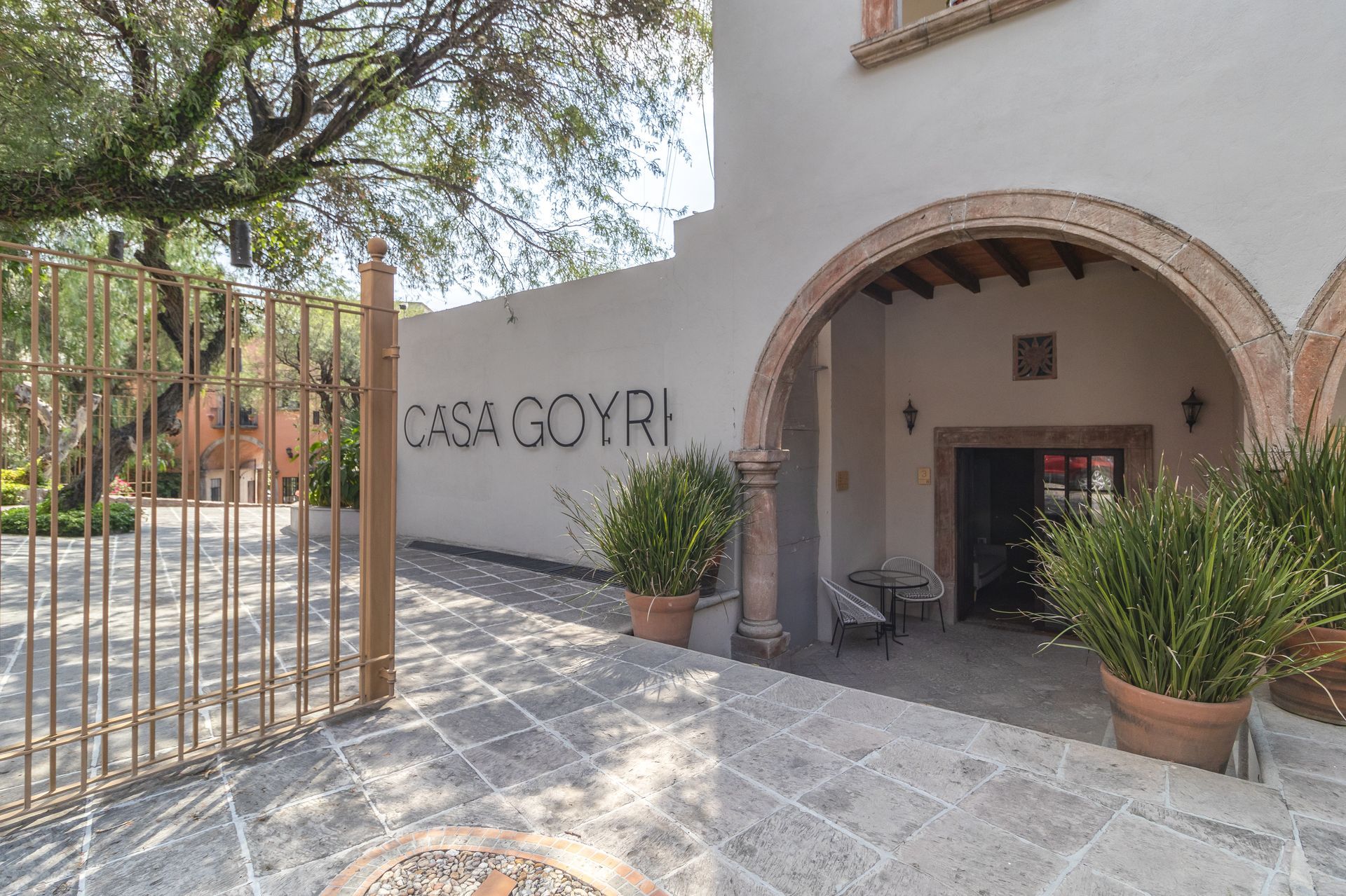 A white building with a fence and a sign that says casa goyri