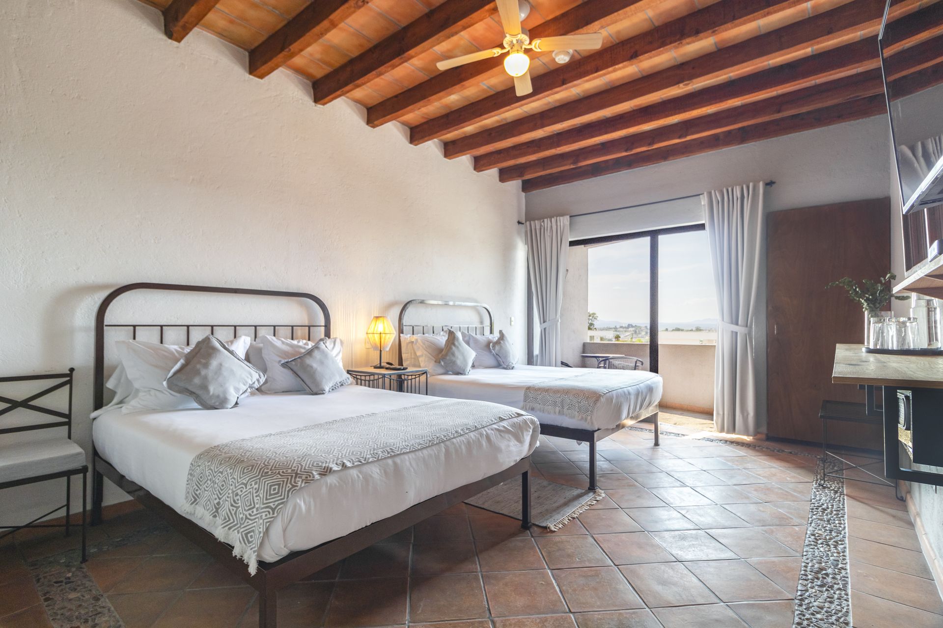 A bedroom with two beds and a ceiling fan.