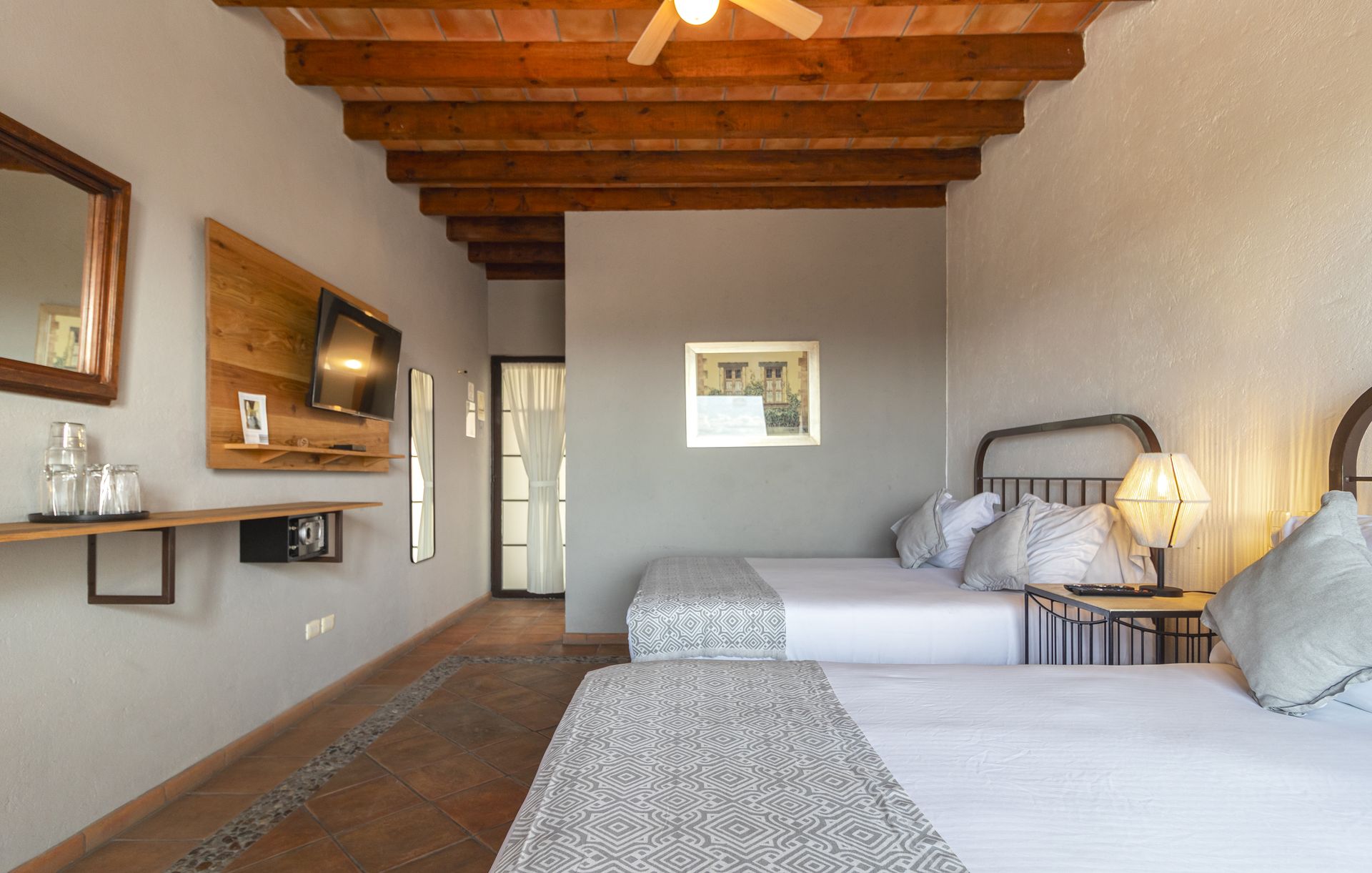 A hotel room with two beds and a ceiling fan.
