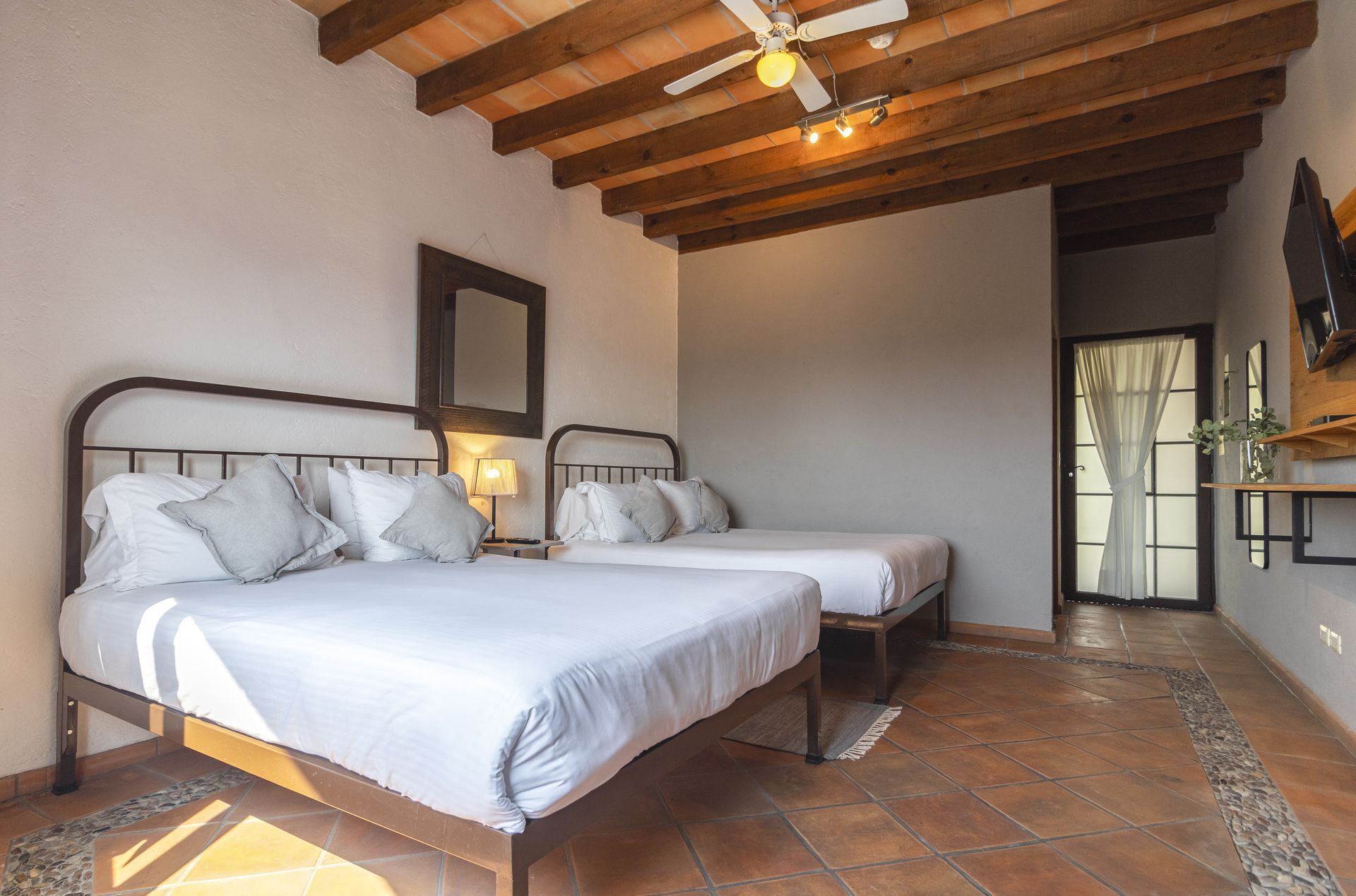 A hotel room with two beds and a ceiling fan.