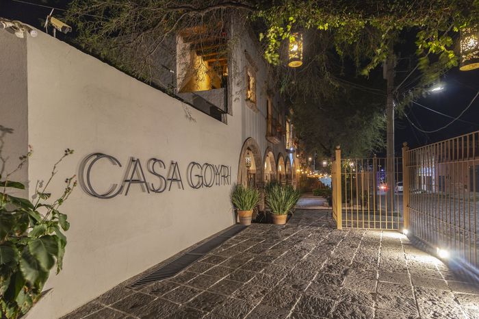 A white wall with the word casa written on it at night.