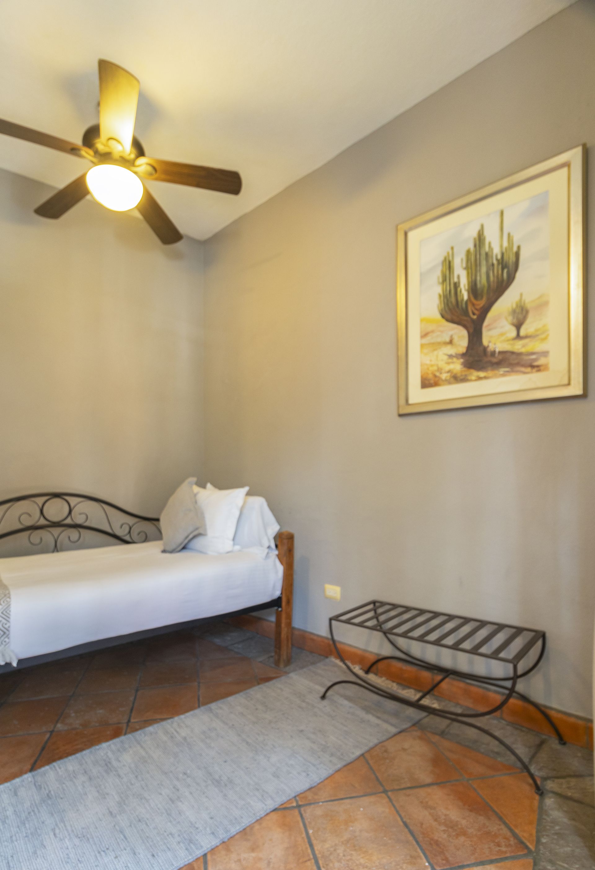 A bedroom with a bed and a ceiling fan