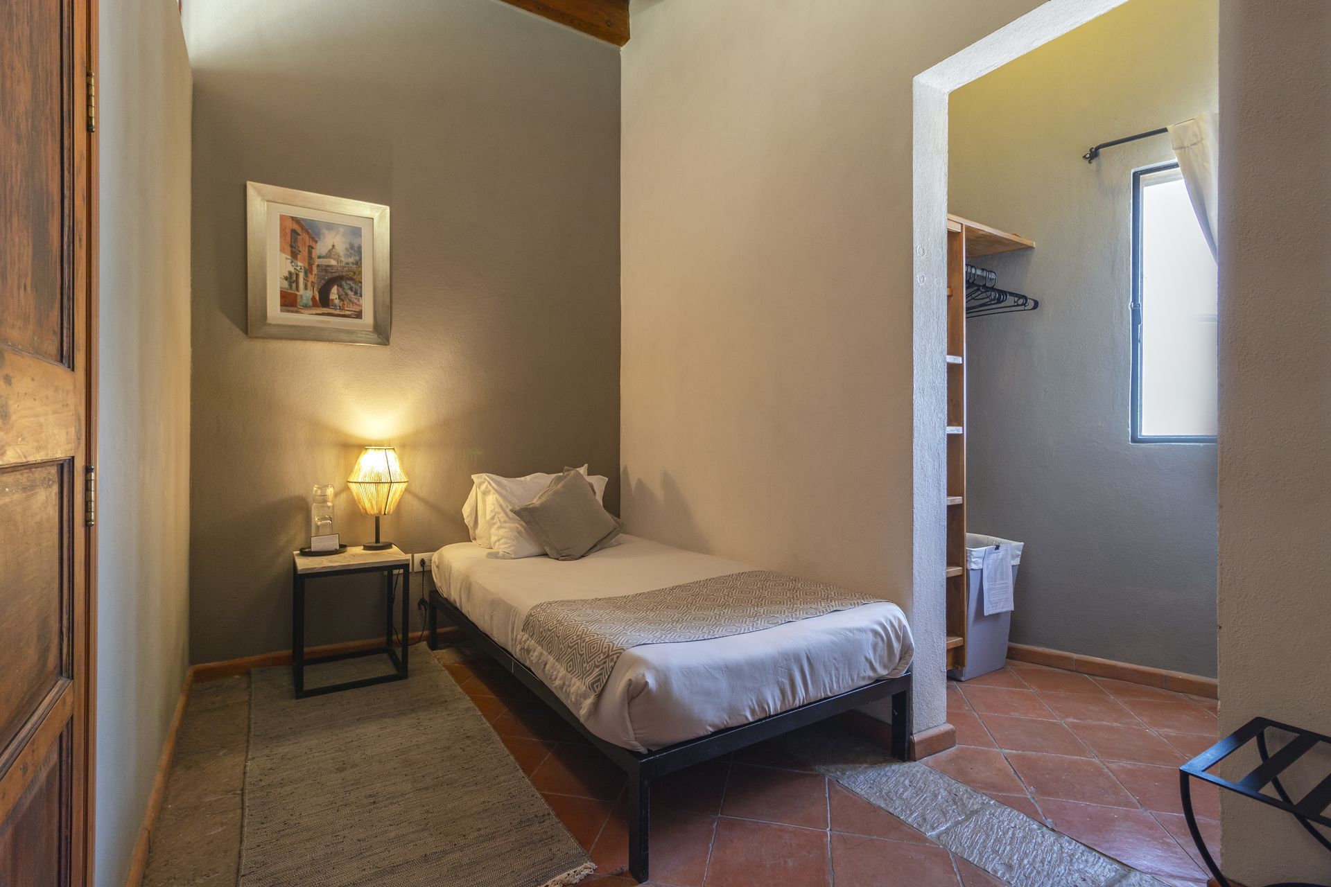 A bedroom with a single bed and a walk in closet.
